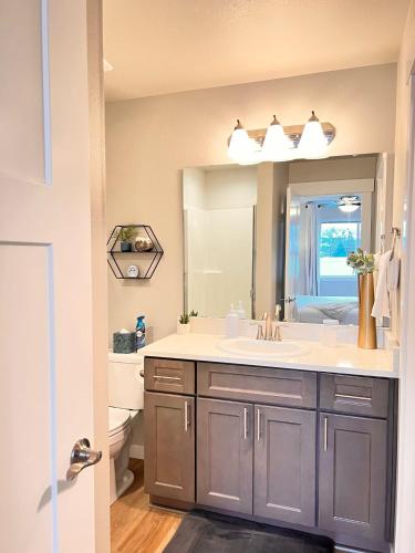 a bathroom with a sink and a large mirror at Modern Style KING bed Free Wi-Fi with Garage in Spokane Valley