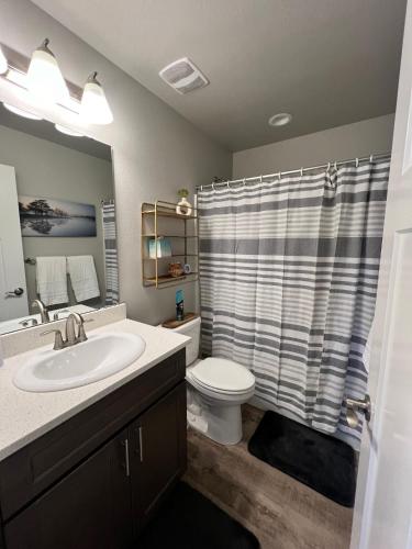 a bathroom with a sink and a toilet and a shower at Modern Style KING bed Free Wi-Fi with Garage in Spokane Valley