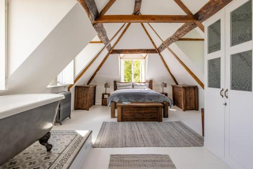 - une chambre mansardée avec un lit et une baignoire dans l'établissement Burnt House Alfriston, Sussex (London-95 mins), à Alfriston