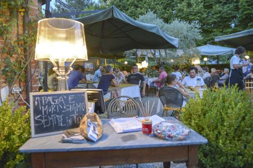 a table with a light on it with people sitting at tables at Casa Di Campagna In Toscana in Sovicille