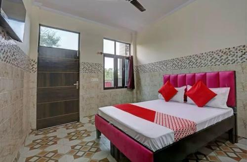 a bedroom with a bed with red pillows and a shower at Hotel Thanks in New Delhi