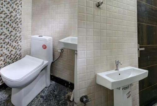a bathroom with a toilet and a sink at Hotel Thanks in New Delhi