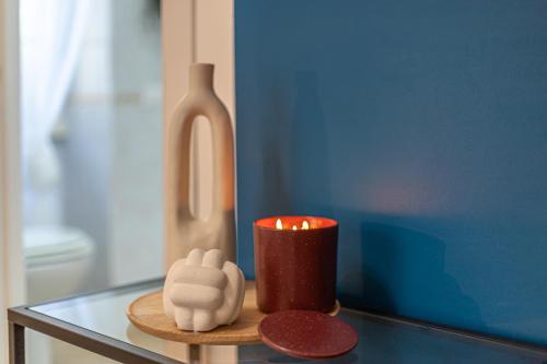a candle sitting on a table next to a bottle at Casa Abeba a Torre Maura in Rome