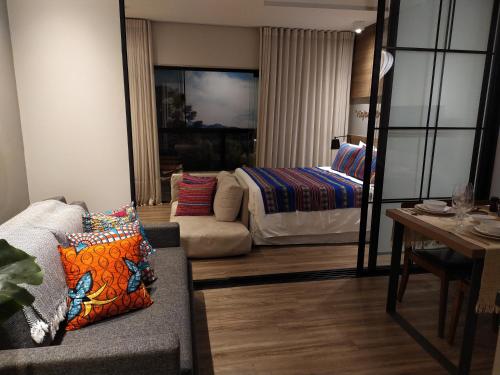 a living room with a bed and a couch at Wanderlust Experience Hotel Best Western in Campos do Jordão