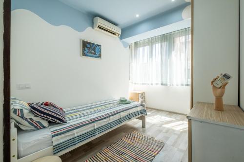 een kleine kamer met een bed en een raam bij Family-friendly place steps from Mall of Sofia in Sofia