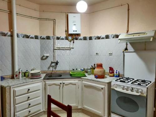 een kleine keuken met een fornuis en een wastafel bij Appartement F3 équipé, spacieux près du centre in Biskra