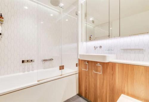 a bathroom with a tub and a sink and a shower at Royal Luxury 3 Beds: Central Covent Garden Haven in London