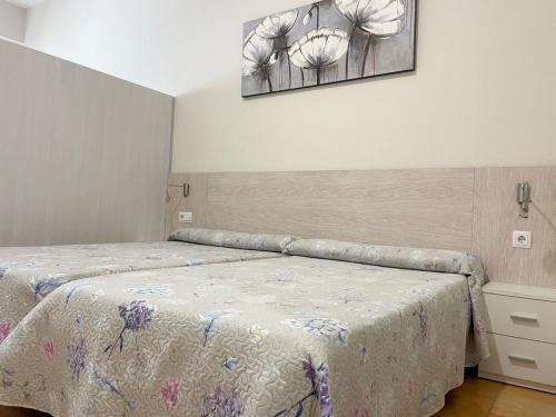1 dormitorio con 1 cama y una foto en la pared en Apartamentos Turisticos Mediterraneo, en Cartagena