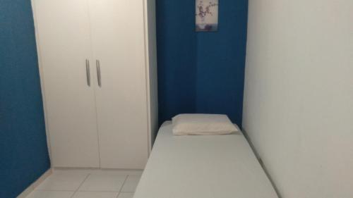 um pequeno quarto com uma cama e um armário em Casa bom lazer em Vera Cruz de Itaparica