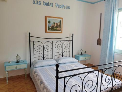 a bedroom with a bed and two blue tables at Locanda D'Ogliastra, in Triei