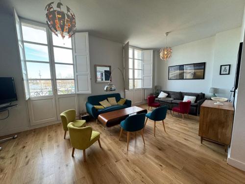 a living room with a couch and a table and chairs at L'annexe Bordeaux Traditions in Bordeaux