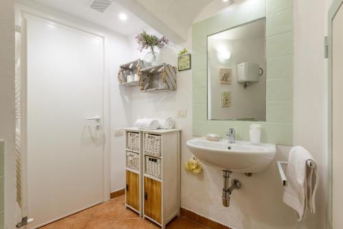 a white bathroom with a sink and a mirror at Casa Vezzosa in Siena