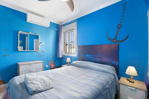 Dormitorio azul con cama y lámpara de araña en El Marinero, en Rota