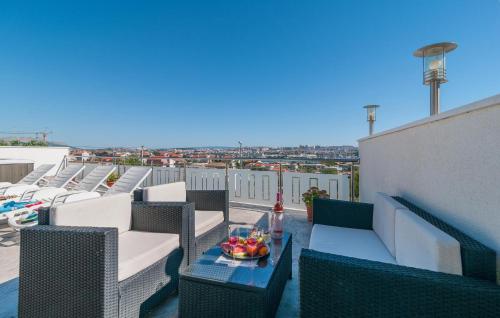 einen Balkon mit Stühlen und einem Tisch mit einer Obstschale in der Unterkunft One-Bedroom Apartment In Solin in Solin