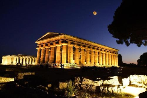 a building with the moon behind it at night at a casa di Chiara bed and breakfast in Capaccio-Paestum