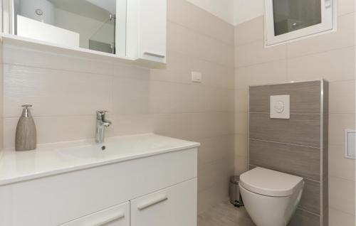a white bathroom with a sink and a toilet at Cozy Apartment In Solin With Kitchen in Solin
