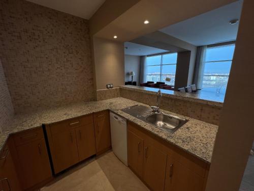 a kitchen with a sink and a large window at Atyrau Executive Apartments in Atyrau