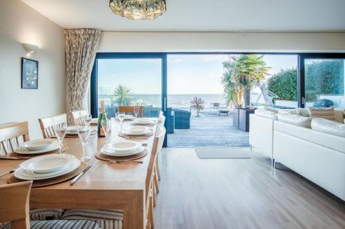 a dining room with a table and a view of the ocean at Beachways - 5 Bedroom Holiday Home - Saundersfoot in Saundersfoot