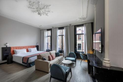 une chambre d'hôtel avec un lit et un canapé dans l'établissement Catalonia Vondel Amsterdam, à Amsterdam