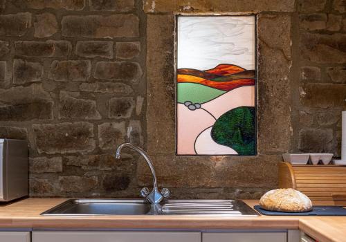 a sink in a kitchen with a painting on the wall at Sandpiper in Feetham