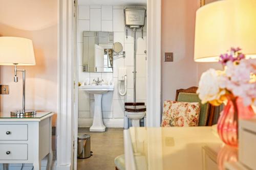 W łazience znajduje się umywalka i lustro. w obiekcie Springwells House w mieście Steyning