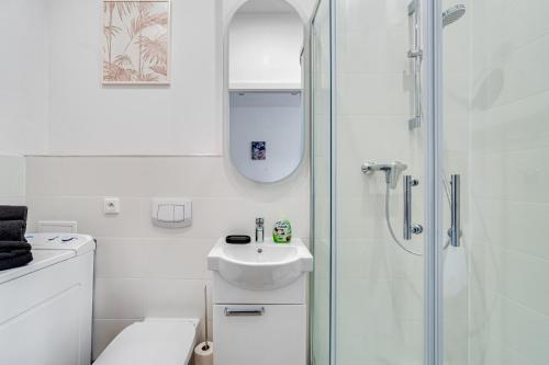 biała łazienka z umywalką i prysznicem w obiekcie Mały Rynek Studio w mieście Opole