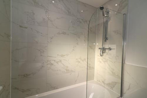 een badkamer met een douche en een glazen deur bij Signature - Sunnyside House in Holytown