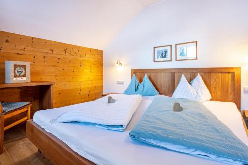 a bedroom with two beds and a wooden wall at Lechnerhof Apt 1 in Braies