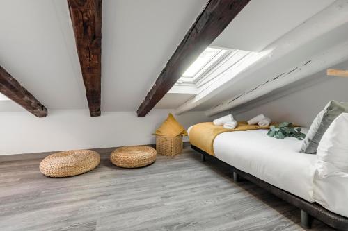 a bedroom with a bed and two stools at Charming Cozy Lavapies in Madrid