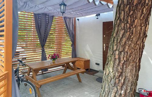 a wooden picnic table in front of a tree at Awesome Home In Lubniewice With Kitchen in Lubniewice