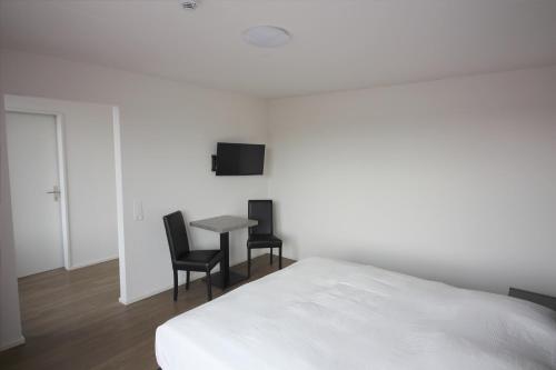 a bedroom with a bed and a table and chairs at Swiss Star Zurich Airport - Self Check-In in Kloten