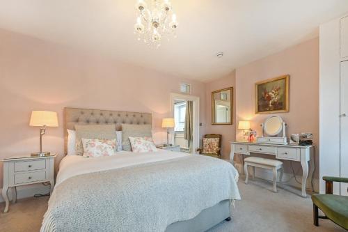 a bedroom with a bed and a desk with a mirror at Springwells House in Steyning