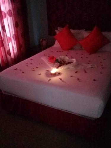 a bedroom with a bed with a candle on it at Reitumetse GuestHouse in Maseru