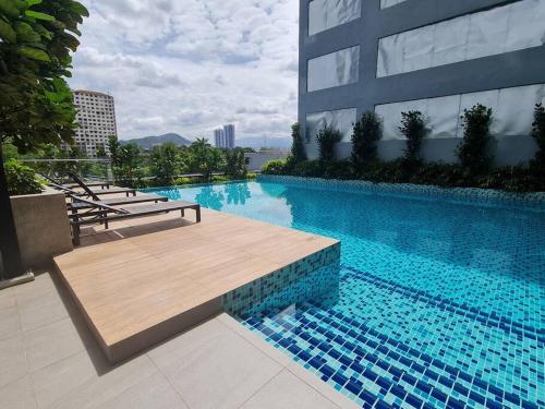 een groot zwembad met een houten bank naast een gebouw bij Studio Room near Gleneagles @ Embassy Row KLCC in Kuala Lumpur