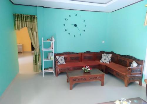sala de estar con sofá rojo y reloj en la pared en Arrang Homestay, en Rantepao