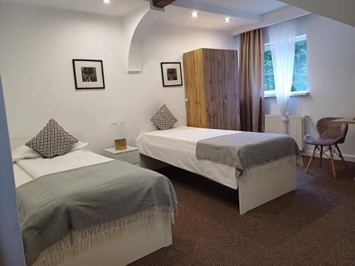 a hotel room with two beds and a chair at Apartamente Private A&L View in Sinaia