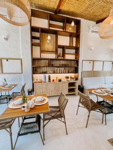 ein Esszimmer mit Tischen und Stühlen und eine Küche in der Unterkunft Pousada Vila de Pedras Noronha in Fernando de Noronha