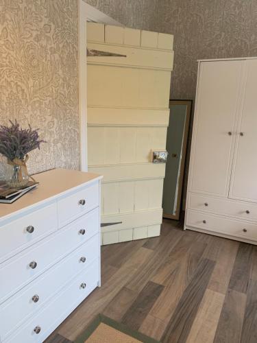 a bedroom with a white dresser and a closet at Old Post Office in Linsfort