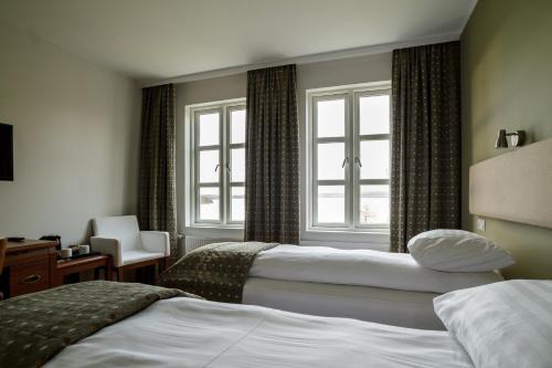 ein Hotelzimmer mit 2 Betten und einem Fenster in der Unterkunft Gistihúsið - Lake Hotel Egilsstadir in Egilsstaðir