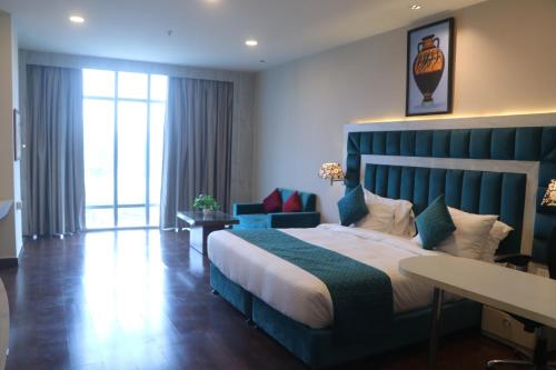 a bedroom with a large bed with a blue headboard at SK Premium Park, World Square Mall in Ghaziabad