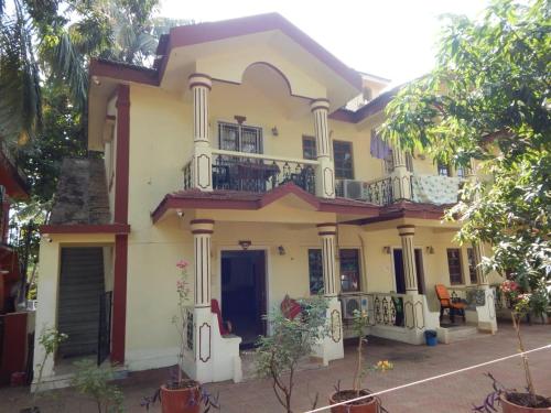 a large yellow house with a balcony at R mansion in Calangute