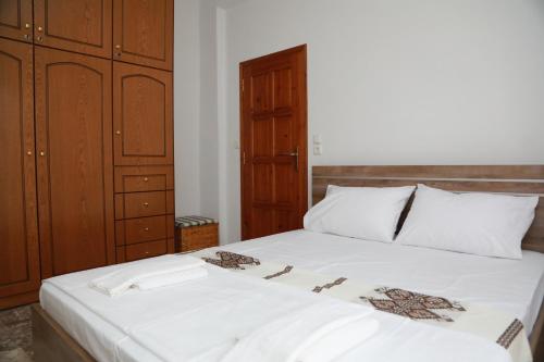 a bedroom with a large white bed with wooden cabinets at Lemon tree house in Kalloni