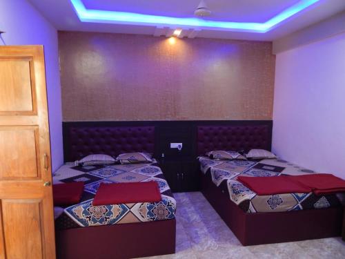 Duas camas num quarto com tecto azul em R mansion em Calangute