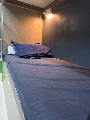 een bed met een blauw kussen in een kamer bij SITARAM DORMITORY in Brahmapur