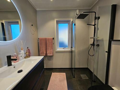 a bathroom with a shower and a sink and a mirror at Tomannsbolig sentralt Stavanger in Stavanger