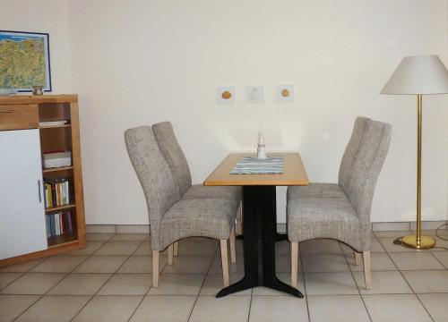 une table à manger avec des chaises et une lampe dans l'établissement Ingeborg - 03-17, à Kühlungsborn