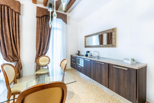 La salle de bains est pourvue d'une table en verre et d'un miroir. dans l'établissement San Teodoro Palace - Luxury Apartments, à Venise