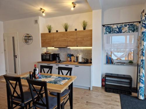 a kitchen with a table and chairs in a room at Dusznickie Apartamenty z widokiem in Duszniki Zdrój