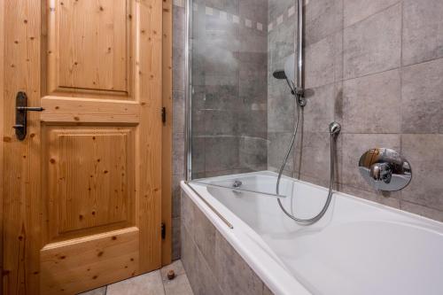 a bathroom with a white tub and a shower at Lechnerhof Apt 3 in Braies