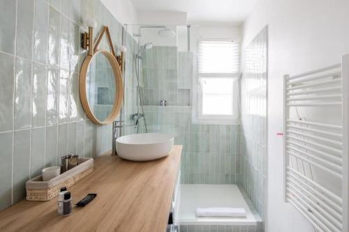 ein Badezimmer mit einem weißen Waschbecken und einem Spiegel in der Unterkunft PARIS 6EME - Studio in Paris